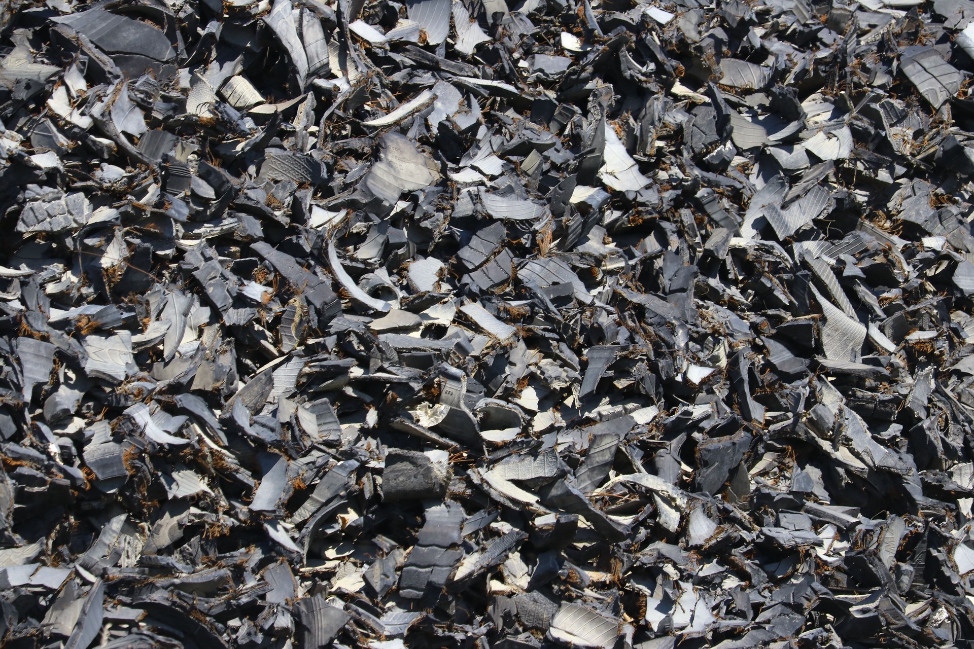 Closeup of a heap of pieces, bits and shards of rubber vehicle tires after being shredded.