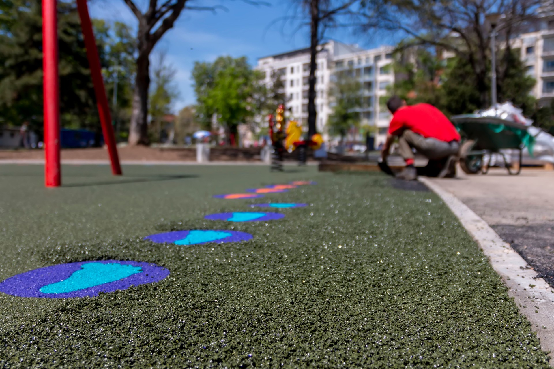 New children's playground under construction. Making a floor with the rubber beads on playground.